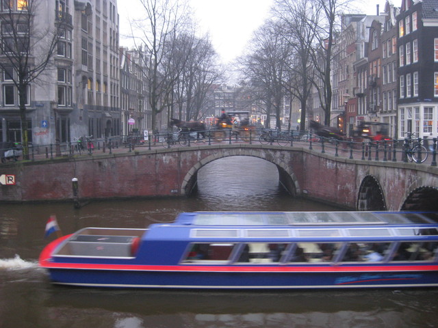 Canal cruise in foreground, horse drawn carriage in background